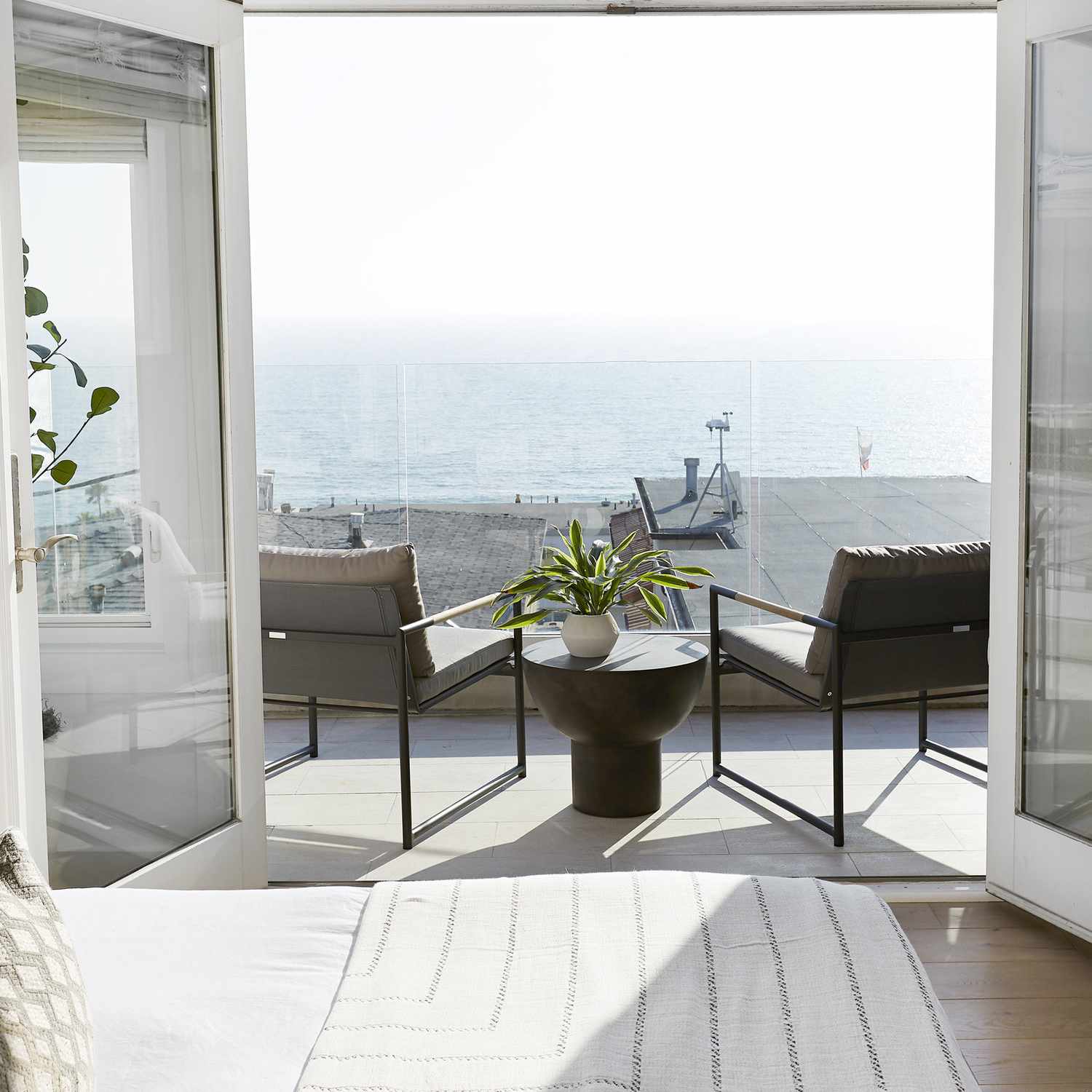 通往阳台的房间装饰简单，有两把椅子，一张小边桌和一株植物