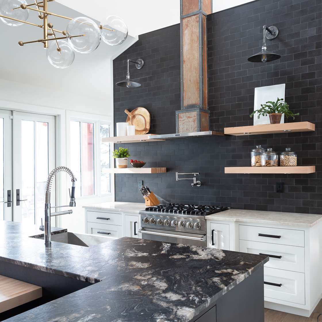 厨房衬有黑色瓷砖，黑色橱柜和黑色大理石台面