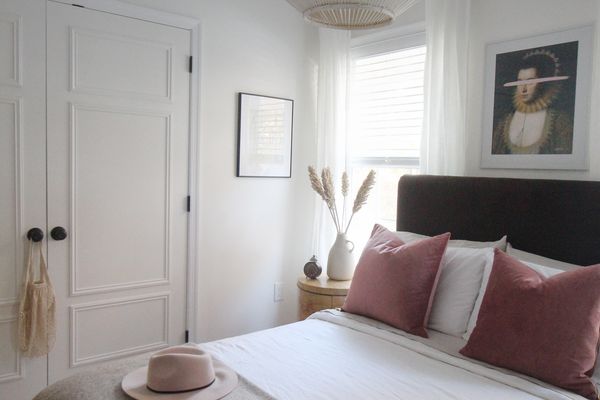 卧室带中性床上用品和粉红色的口音