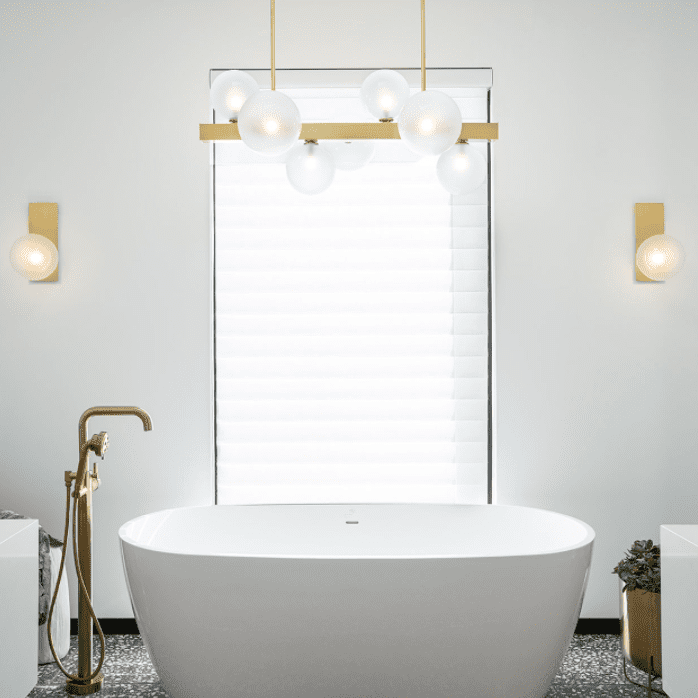 一间带有独立浴缸、水磨石地板和几盏几何灯的浴室