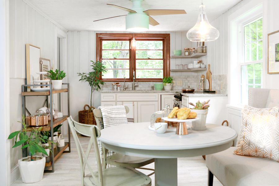 奶油白色的厨房，木制的窗户和薄荷绿色的吊扇