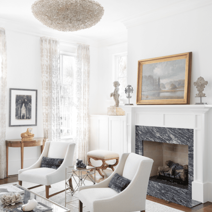 一间带灰色大理石壁炉的全白色客厅