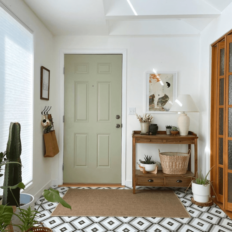 鼠尾草绿色门旁边的天然木材装饰。