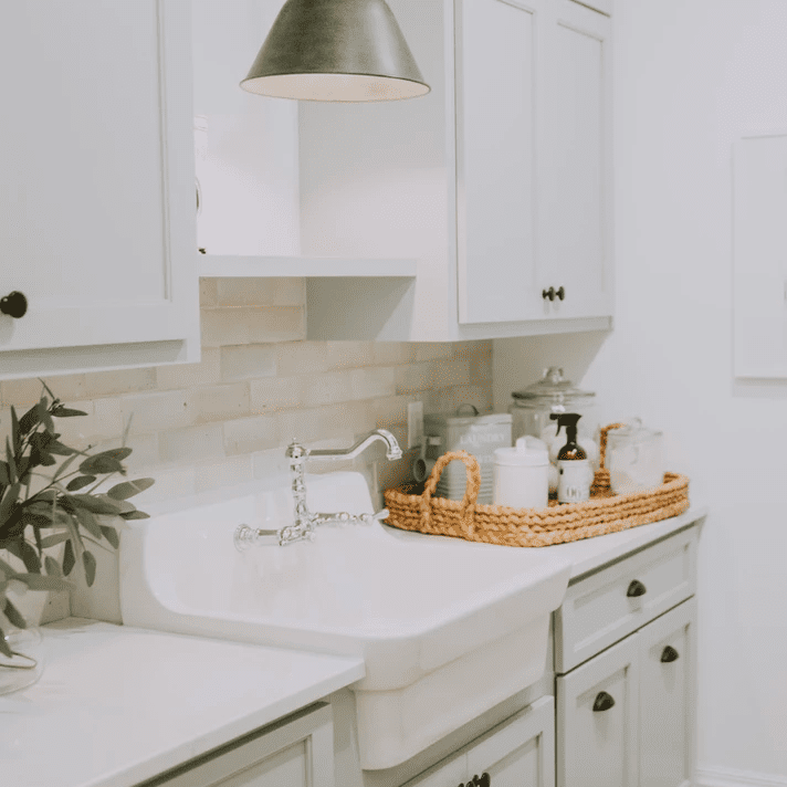 白色的厨房里有一个装满用品的篮子