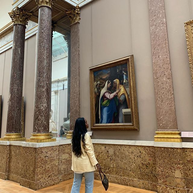 一个女人逛美术馆获得一些文化。