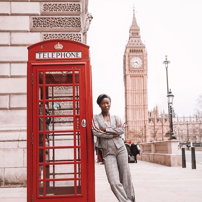 一个女人用红色的伦敦电话亭站在