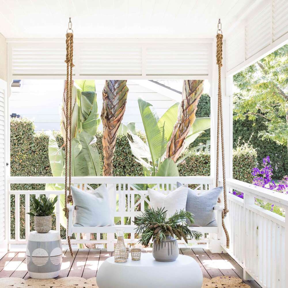 装满地毯，门廊秋千和一张小桌子的甲板