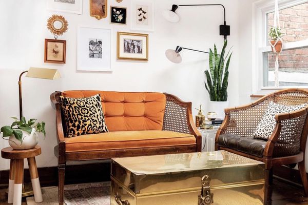 不拘一格的客厅，橙色的沙发，金色的咖啡桌和凳子。