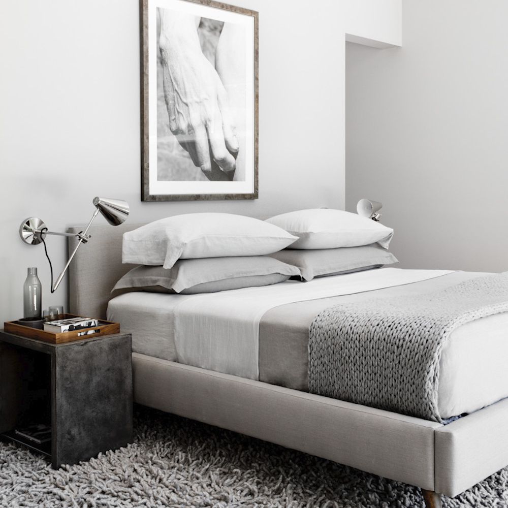 一间浅灰色卧室，配有板岩灰色床头柜