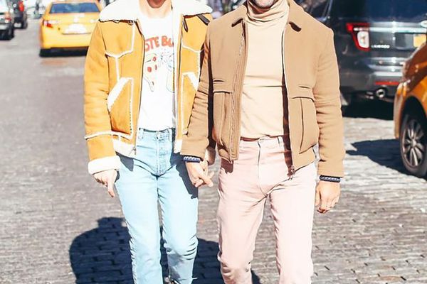 couple walking hand in hand down a busy city street