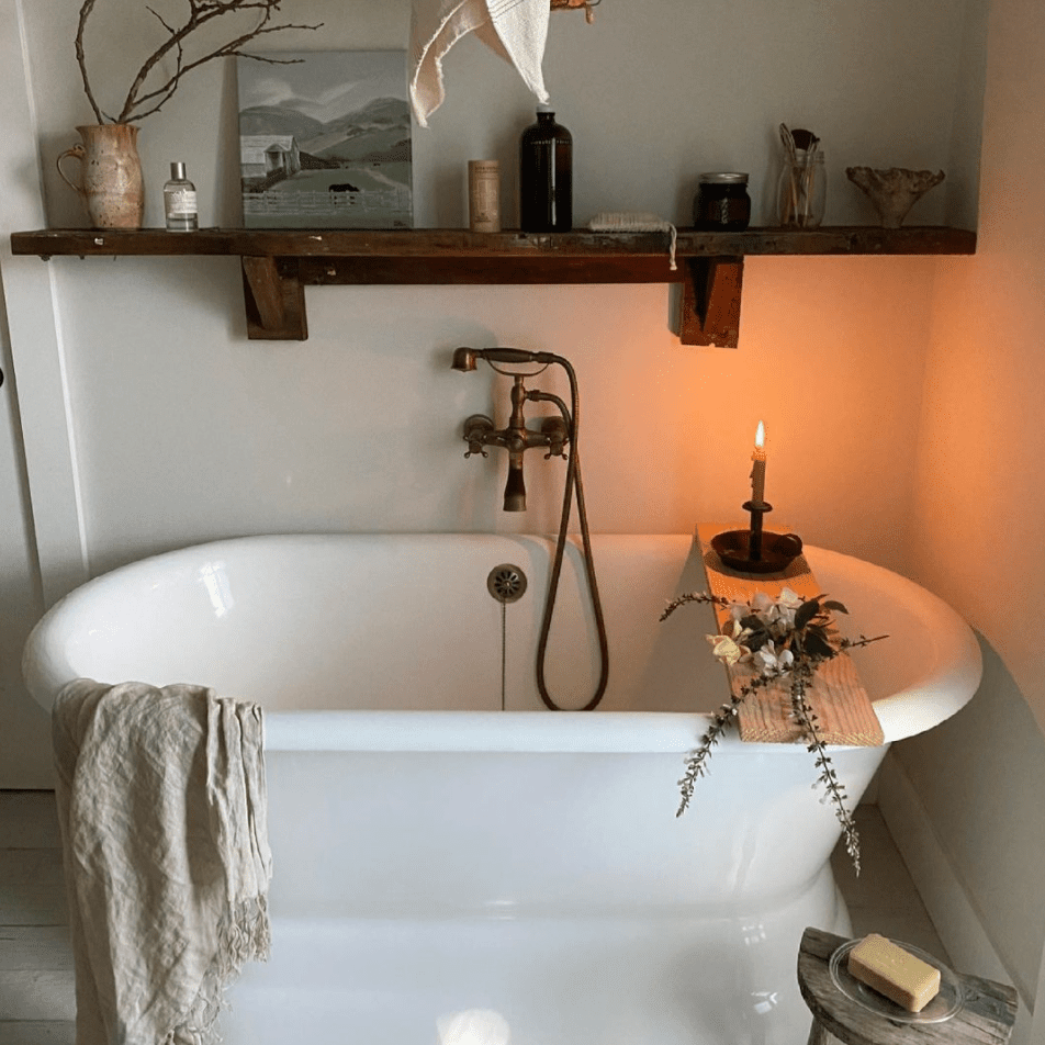 浴室里有一个独立的浴缸和一个质朴的木制架子