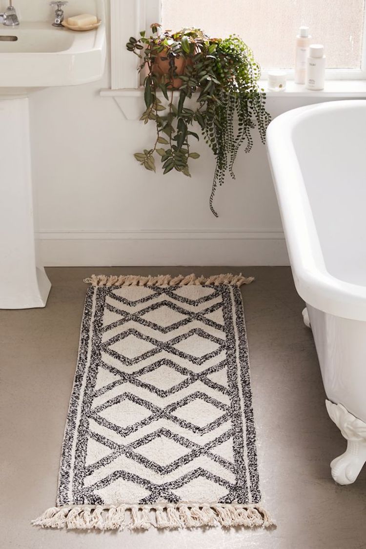 A gray and white printed bath mat in a bathroom