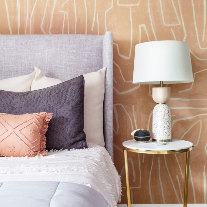 卧室配有紫色床和大胆的桃色彩色壁纸
