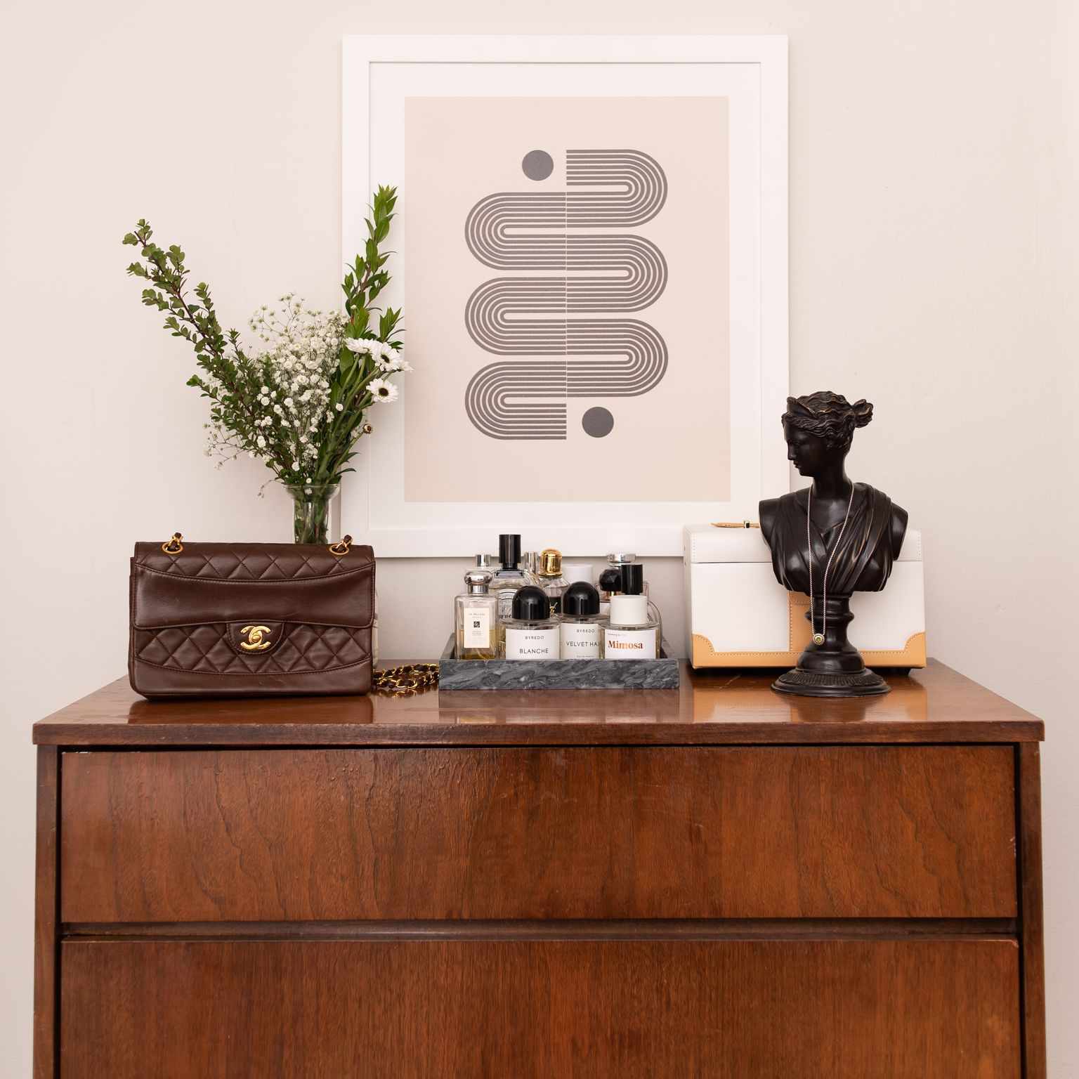 Dresser with bust sculpture and Parisian decor.