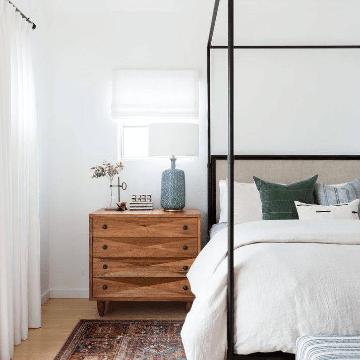 一间色彩斑斓的房间，有红色印花地毯和黑色顶棚床