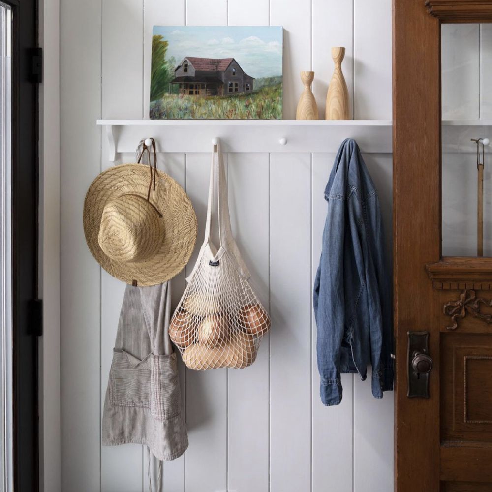 夹克，围裙和牛仔夹克悬挂在白色钉架