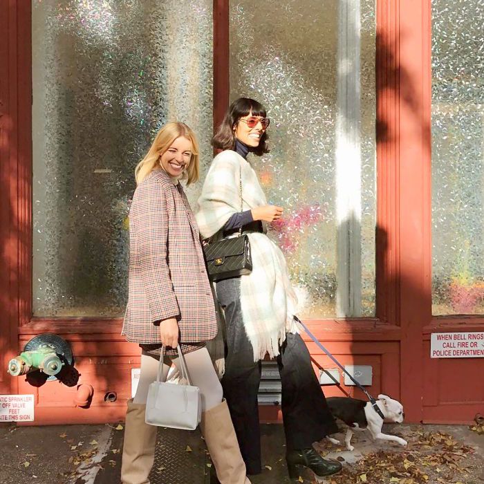 两个女人一起微笑着走在人行道上