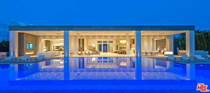 住宅的全景，经过游泳池，可以看到开放式的生活空间。