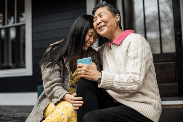 一个成年女人和年长的母亲在前廊聊天