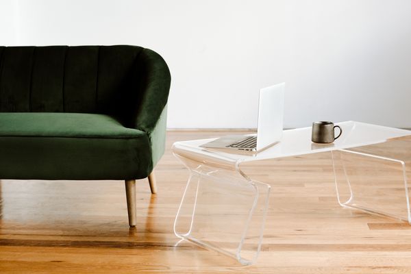 绿色天鹅绒沙发和透明玻璃桌子。