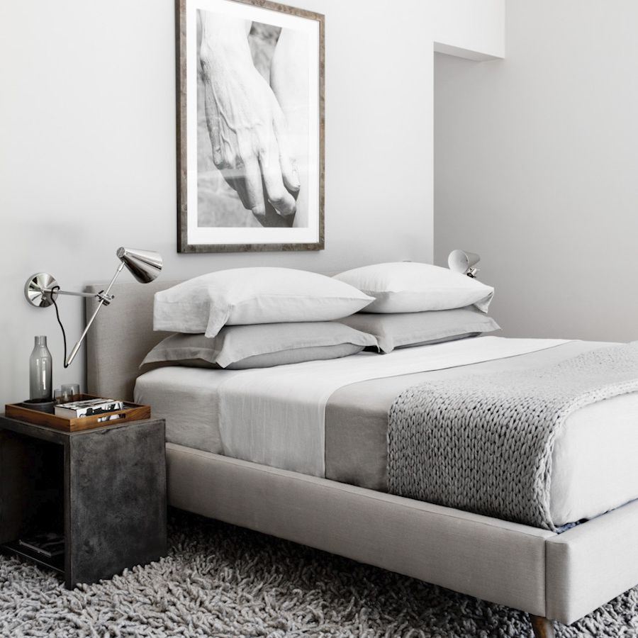 一间全灰色的卧室，配有光滑的银色烛台