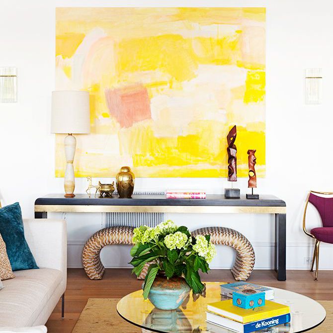 一个大的白色和黄色的抽象绘画与灯等艺术作品的侧表上方挂