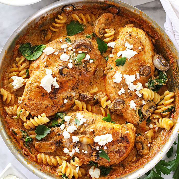 一盘鸡肉奶油晒干的番茄香草酱