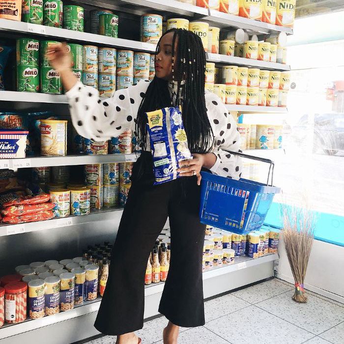 年轻的人对货架上的购物臂到达篮产品