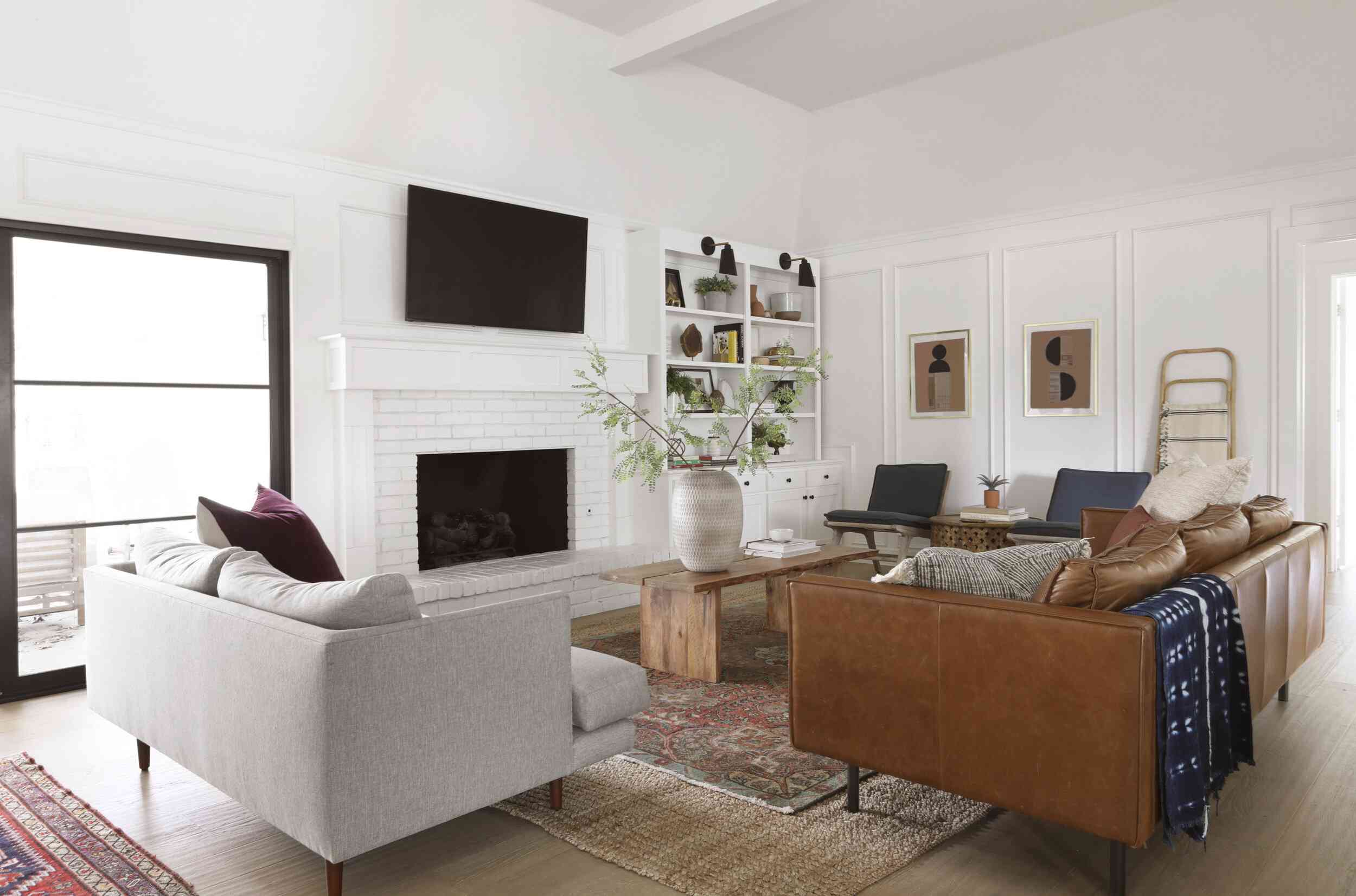 best living room ideas - white walls with caramel colored couches and warm accents