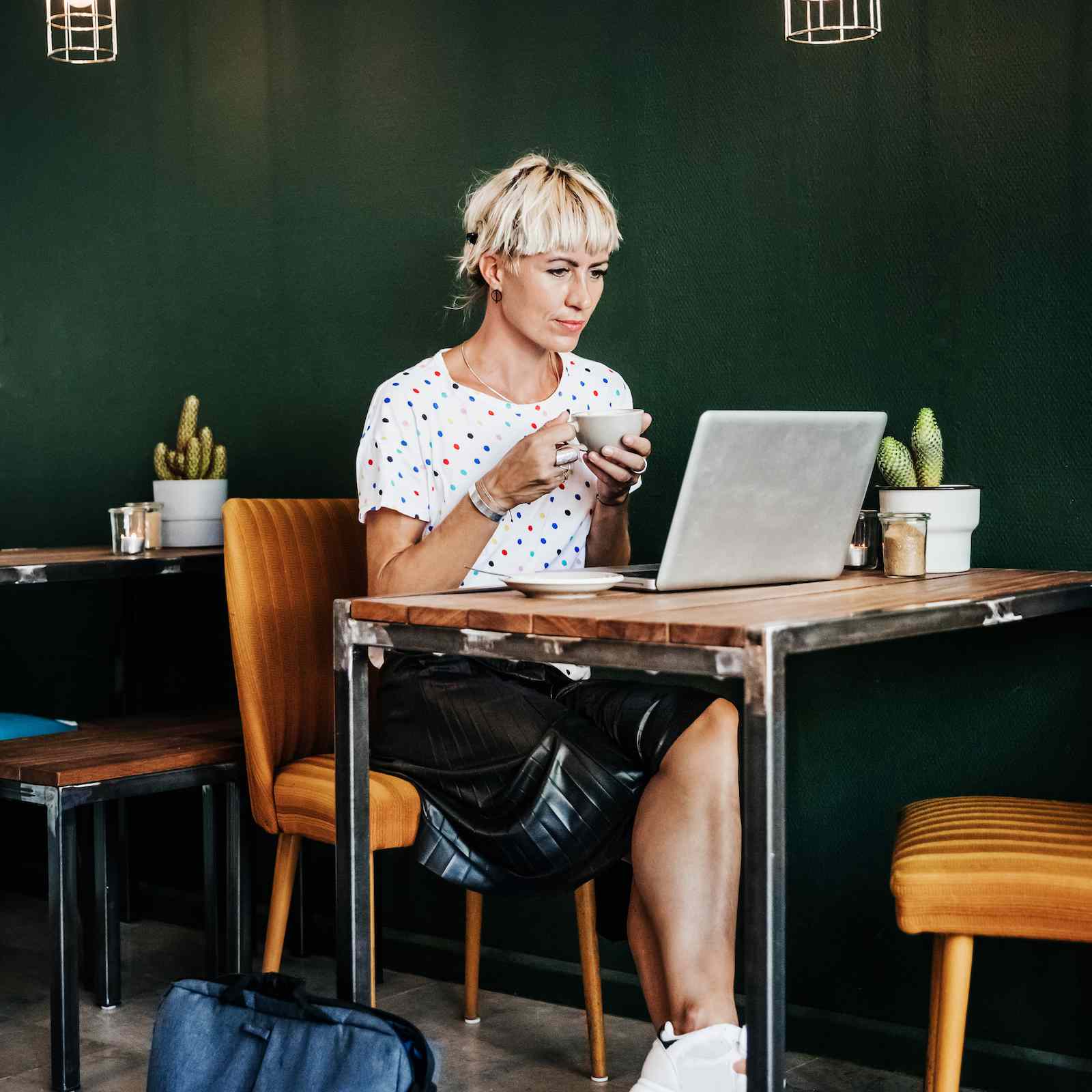 一个在咖啡店里用笔记本电脑工作的女人。