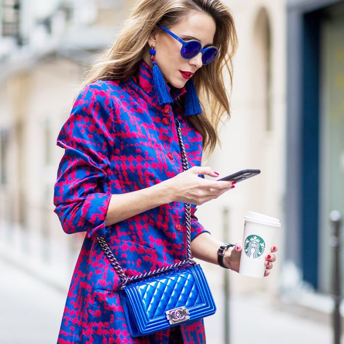 一个女人在看她的手机，而过马路