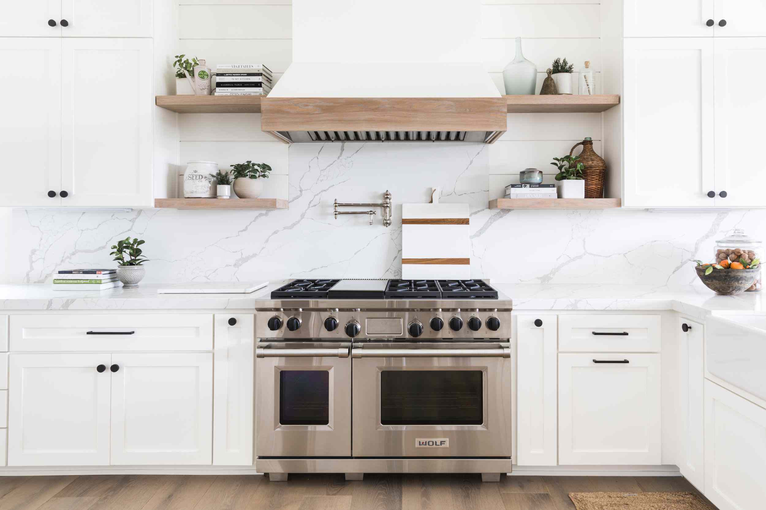 一间全白色厨房，配有橱柜和货架的组合