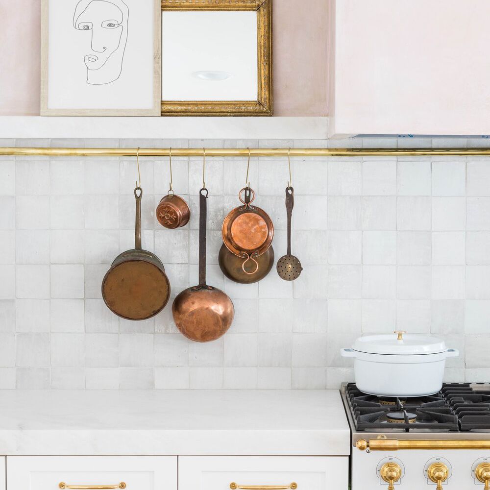 粉红色墙壁，白色瓷砖和煤气炉的厨房