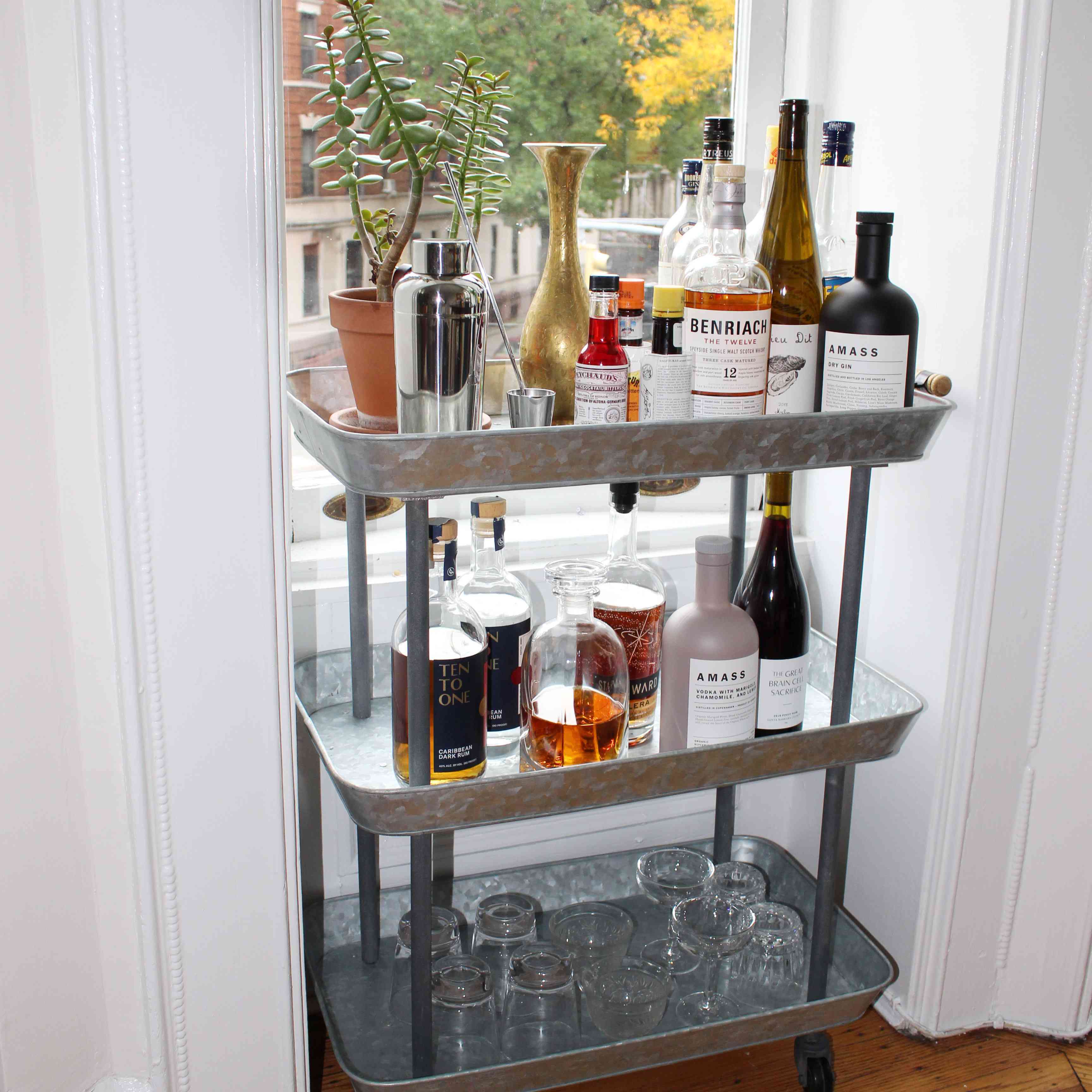 well-stocked bar cart by a window