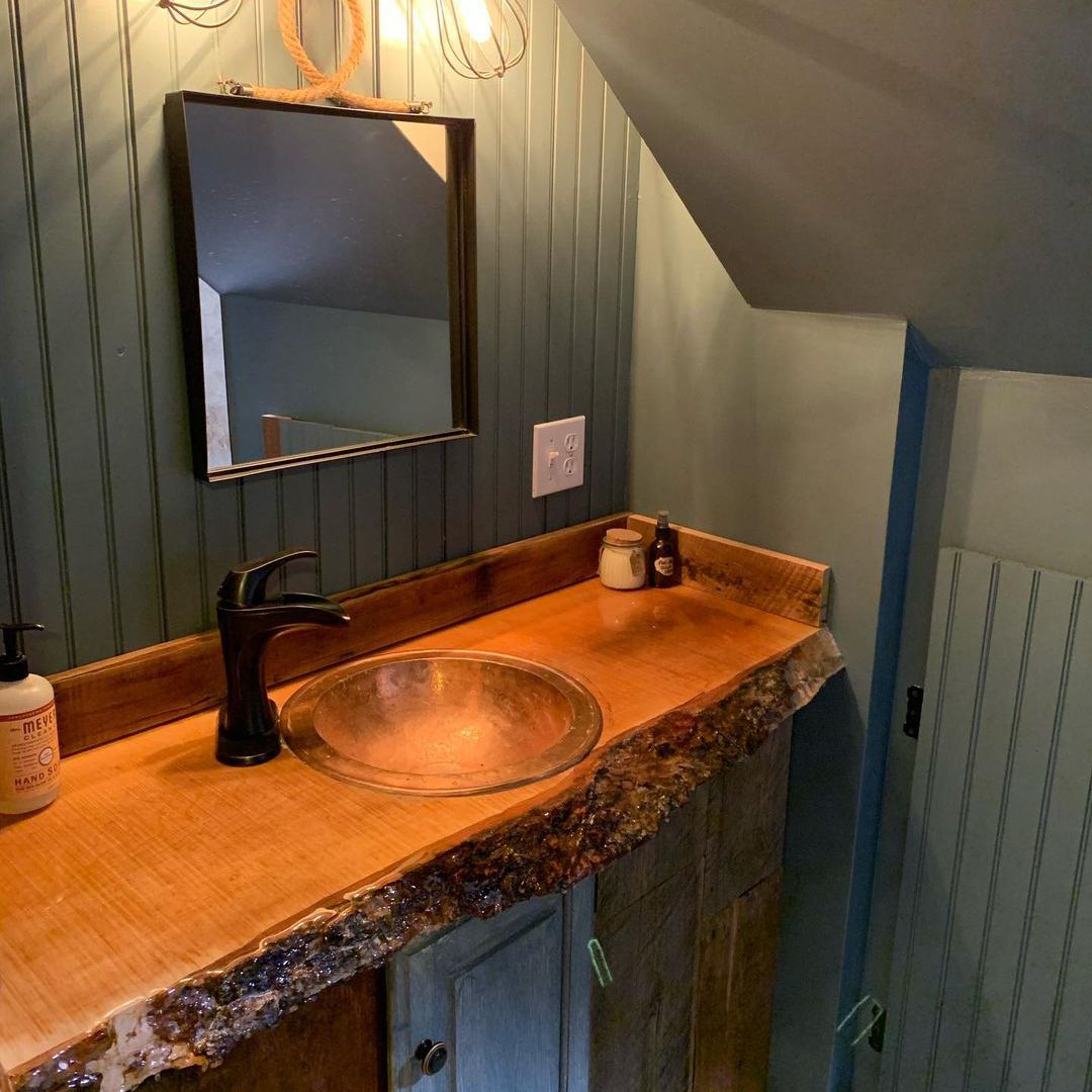 浴室有绿色的墙壁和木制梳妆台