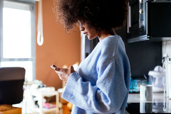 a woman in the kitchen texting