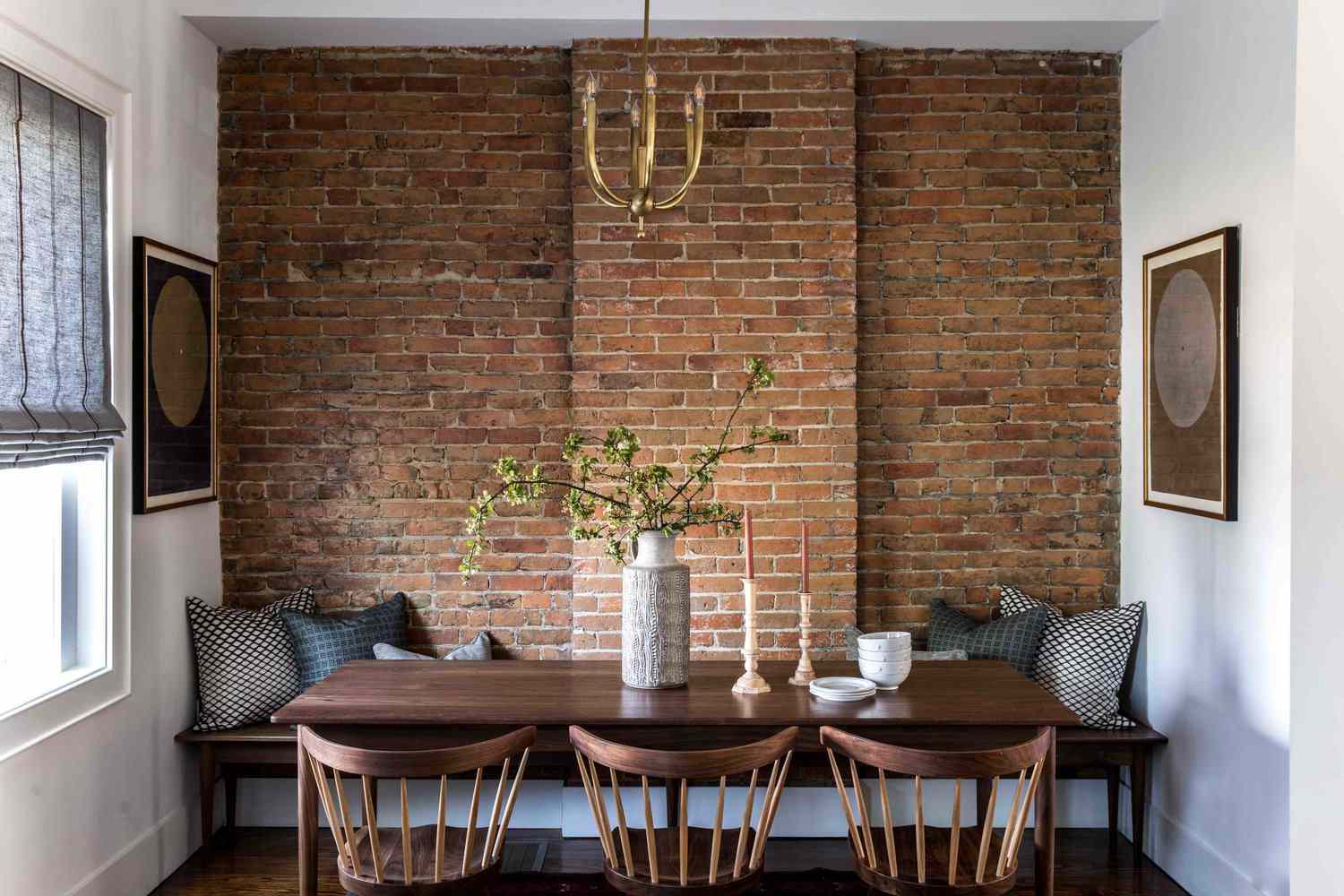 一张木制餐桌，上面有烛台、一株植物和几只碗