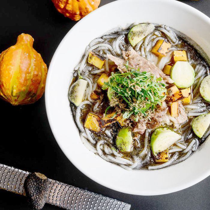 一碗米线面，周围是三个橙子南瓜