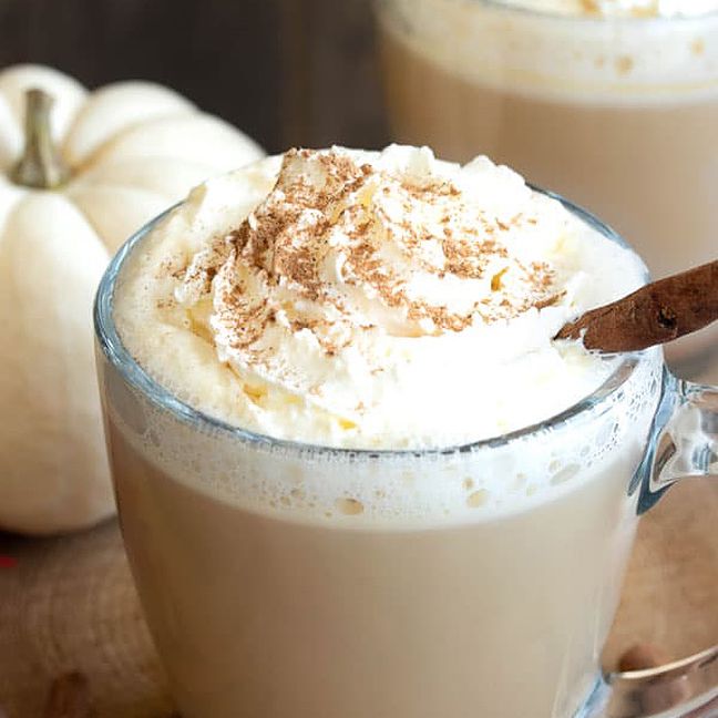 一杯喝得醉醺醺的南瓜香料拿铁与鲜奶油和肉桂。