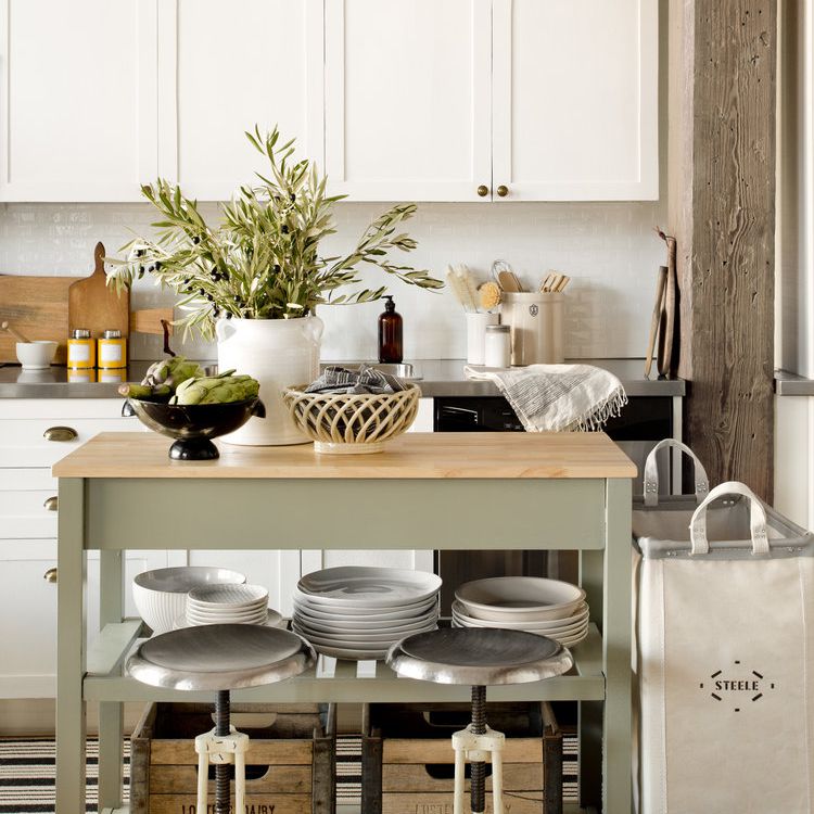 一个带有薄荷绿色厨房岛和几个仿古木质口音的小白色厨房