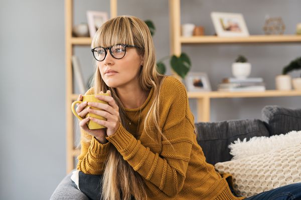 拿着杯子看电视的女人