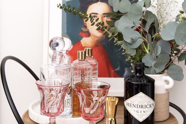 酒吧区有粉色酒杯、绿色植物和艺术品。