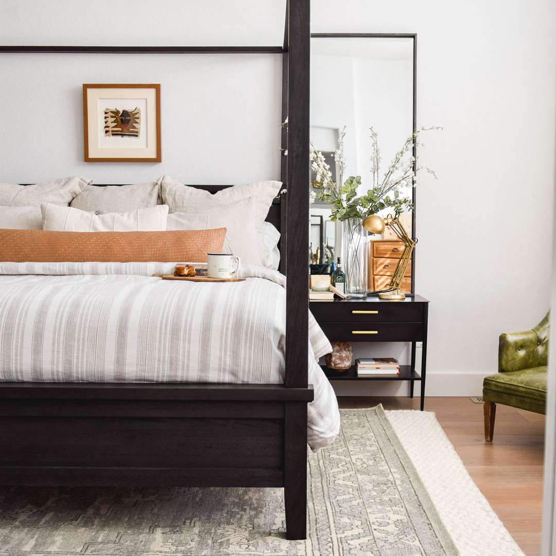 中性卧室，有遮篷床和很多枕头。