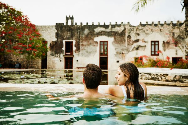 一对夫妇在游泳池里一个女人看着一个男人，那个男人在看她