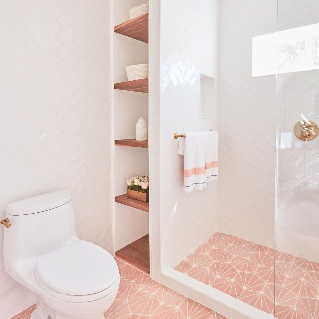 粉红色的浴室，浴室旁边有马桶