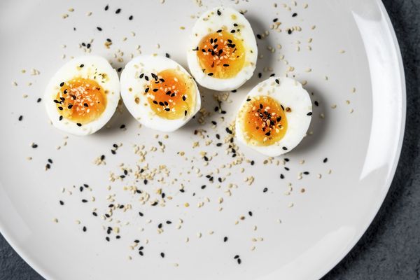 Halved hard boiled eggs with pepper on a white plate.