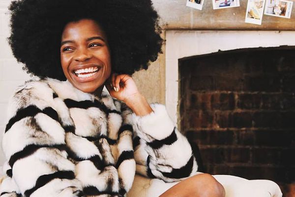 坐在壁炉前面的愉快的妇女