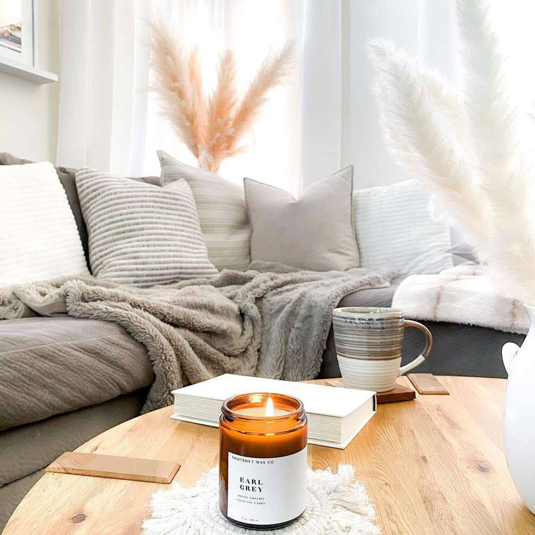 舒适的客厅配有点燃的蜡烛和咖啡杯。