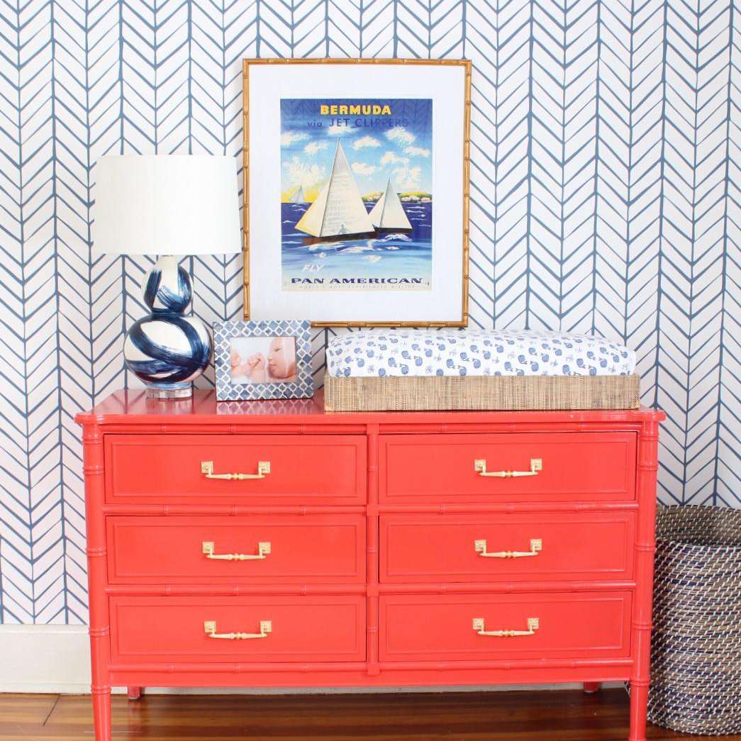 有挂在上面葡萄酒百慕大海报的明亮的橙色梳妆台。