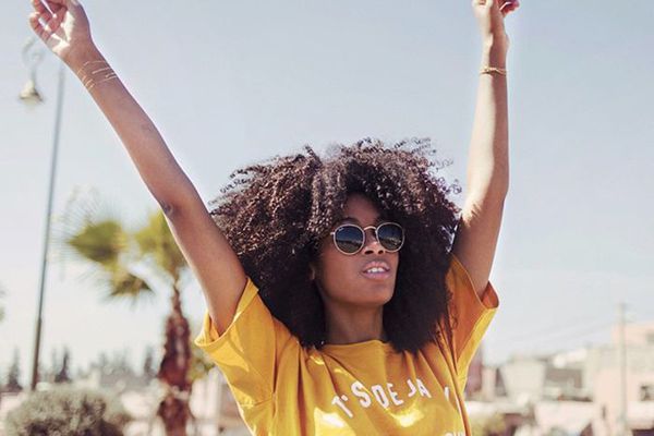 戴着太阳镜的妇女用她的手在空中举行。